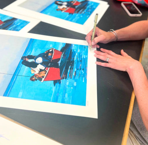 woman signing art prints